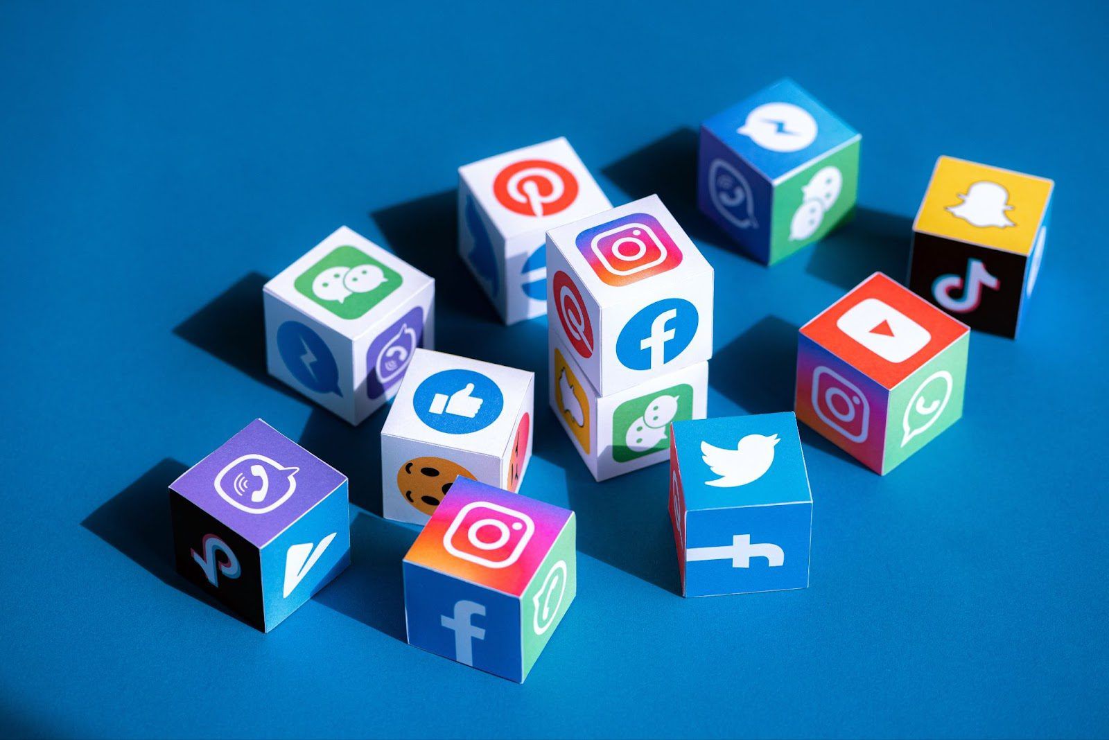 Collection of dice with various social media and messaging app icons on a blue background.